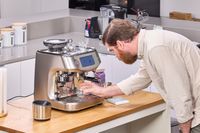 A person places a mug under the Breville The Oracle Dual Boiler Espresso Machine