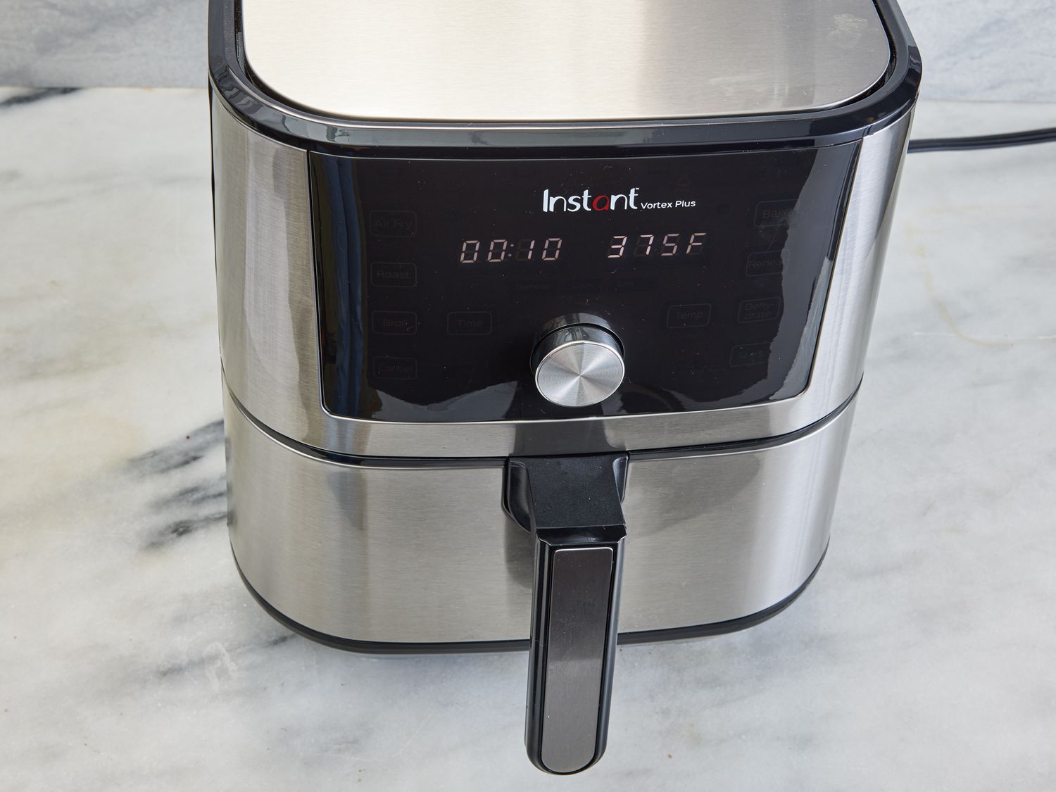 An air fryer is preheated to 375 degrees Fahrenheit.