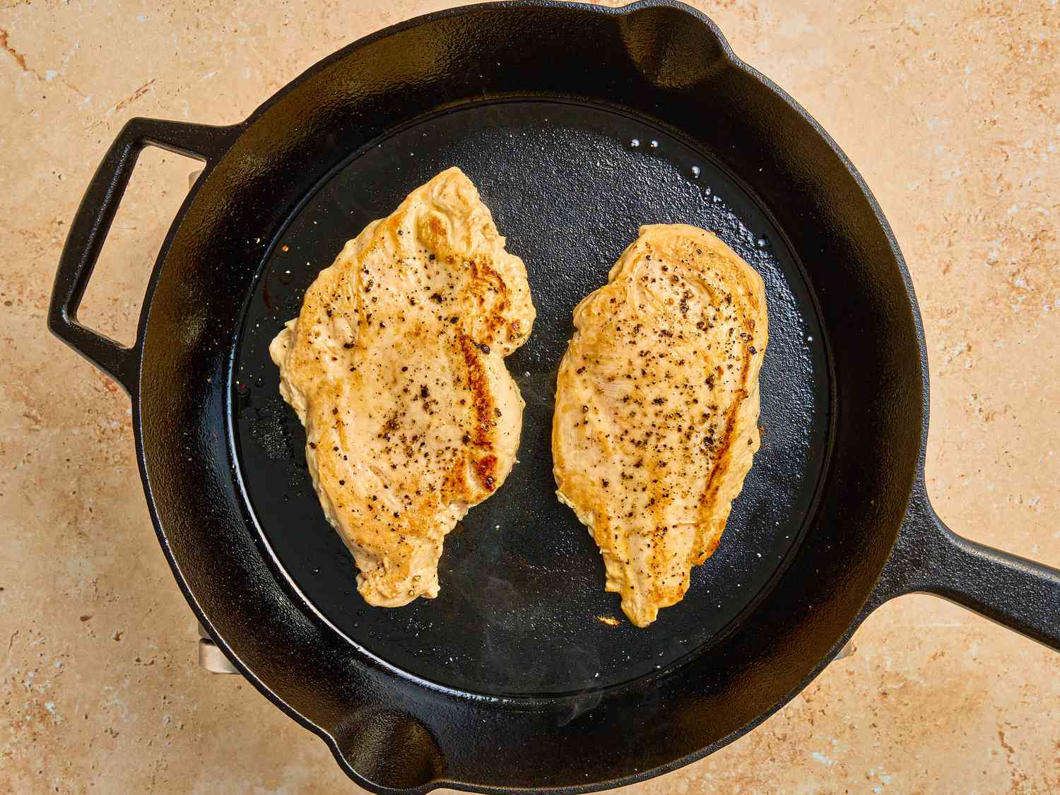 Frying chicken breasts on a skillet