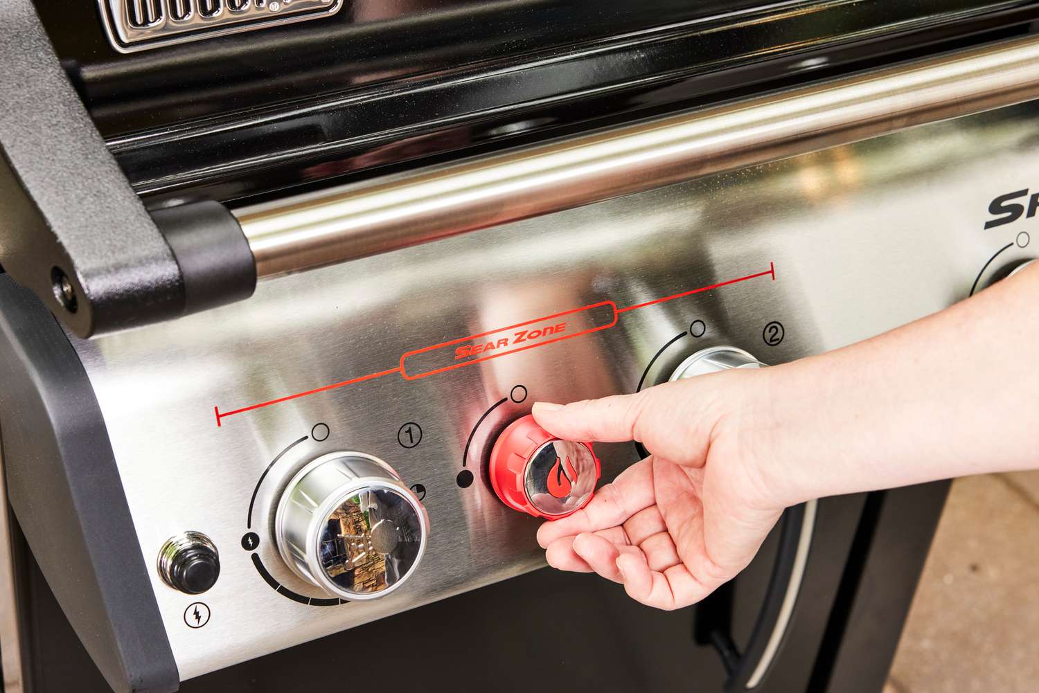 A person adjusts the temperature on the Weber Spirit EX-325s Smart Grill