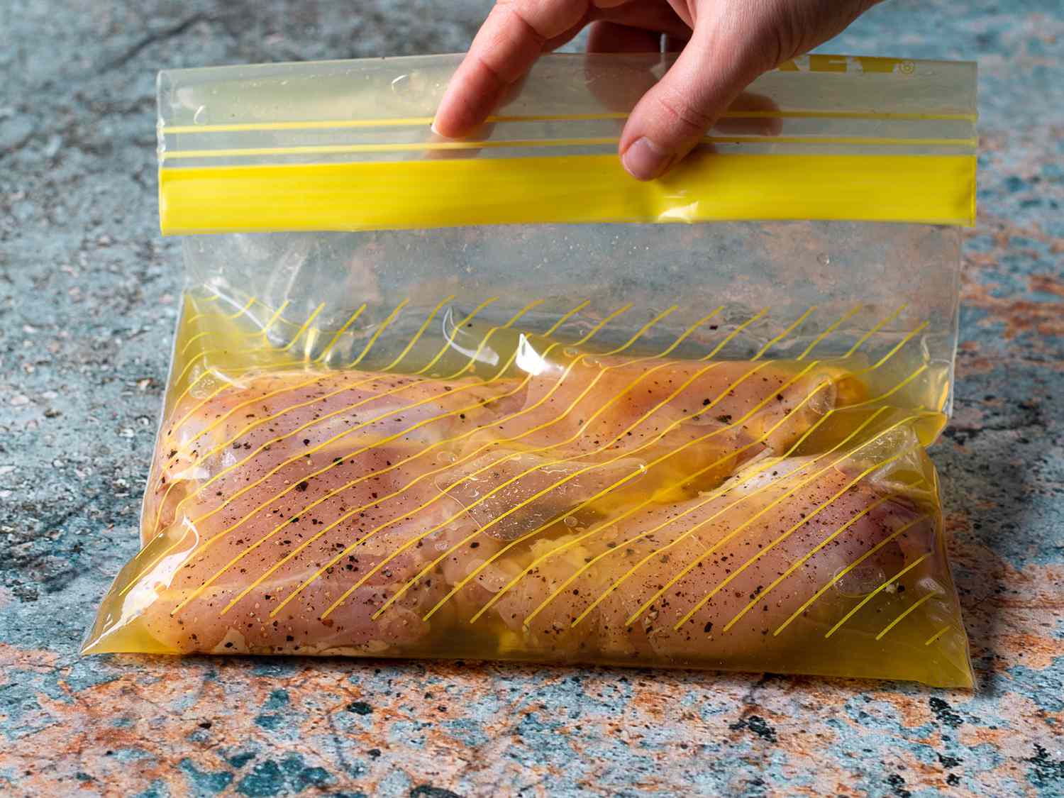 Chicken brining in pickle juice in a plastic zipper lock bag.