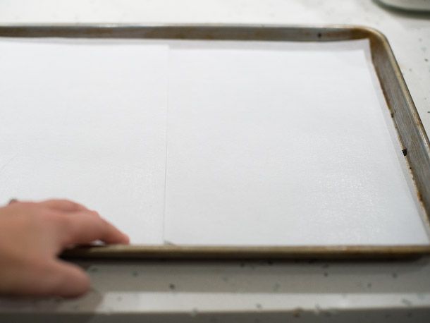 A sheet pan is lined with parchment and edible wafer paper.