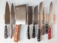 An assortment of knives on a wooden knife strip