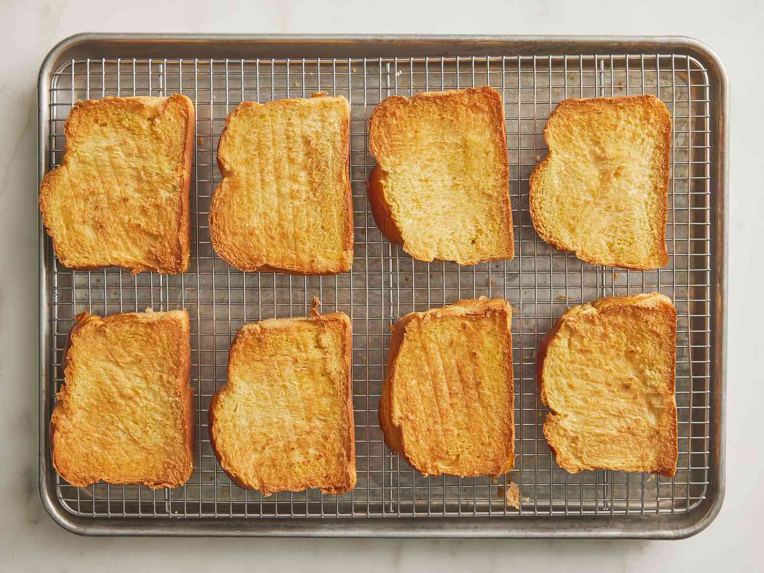 Toasted bread lined up together on a cooling rack 