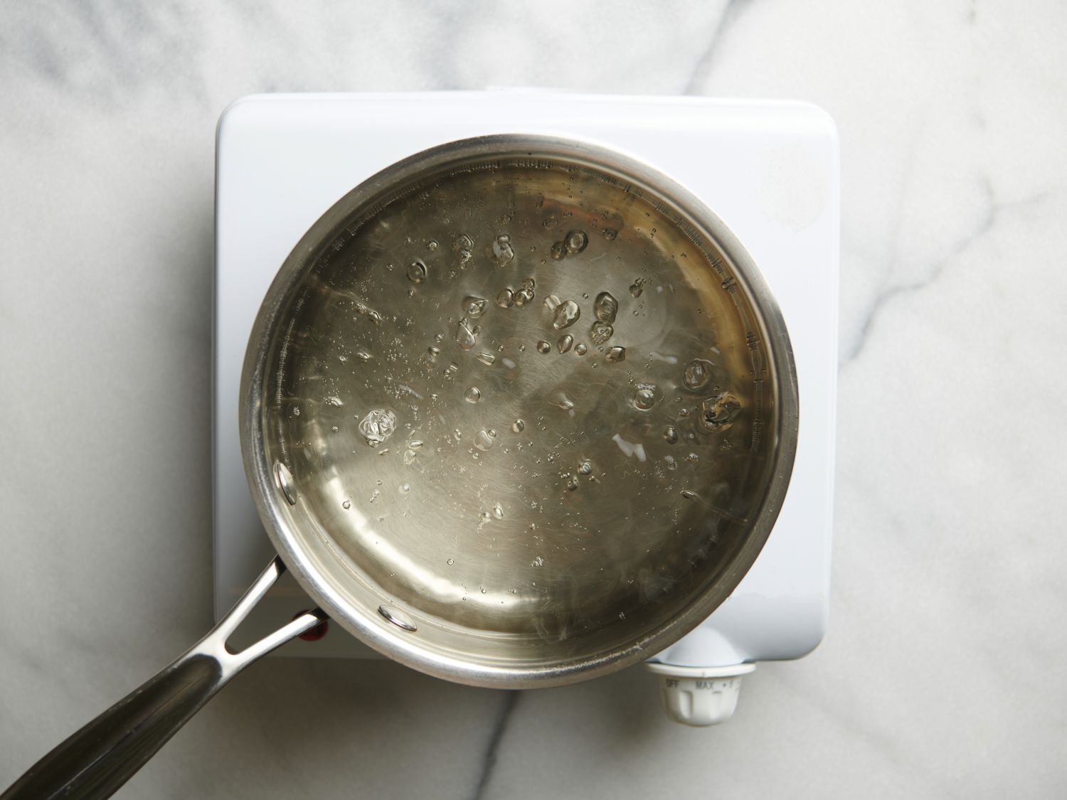 Water and sugar boiling over medium heat in small stainless steel saucepan.
