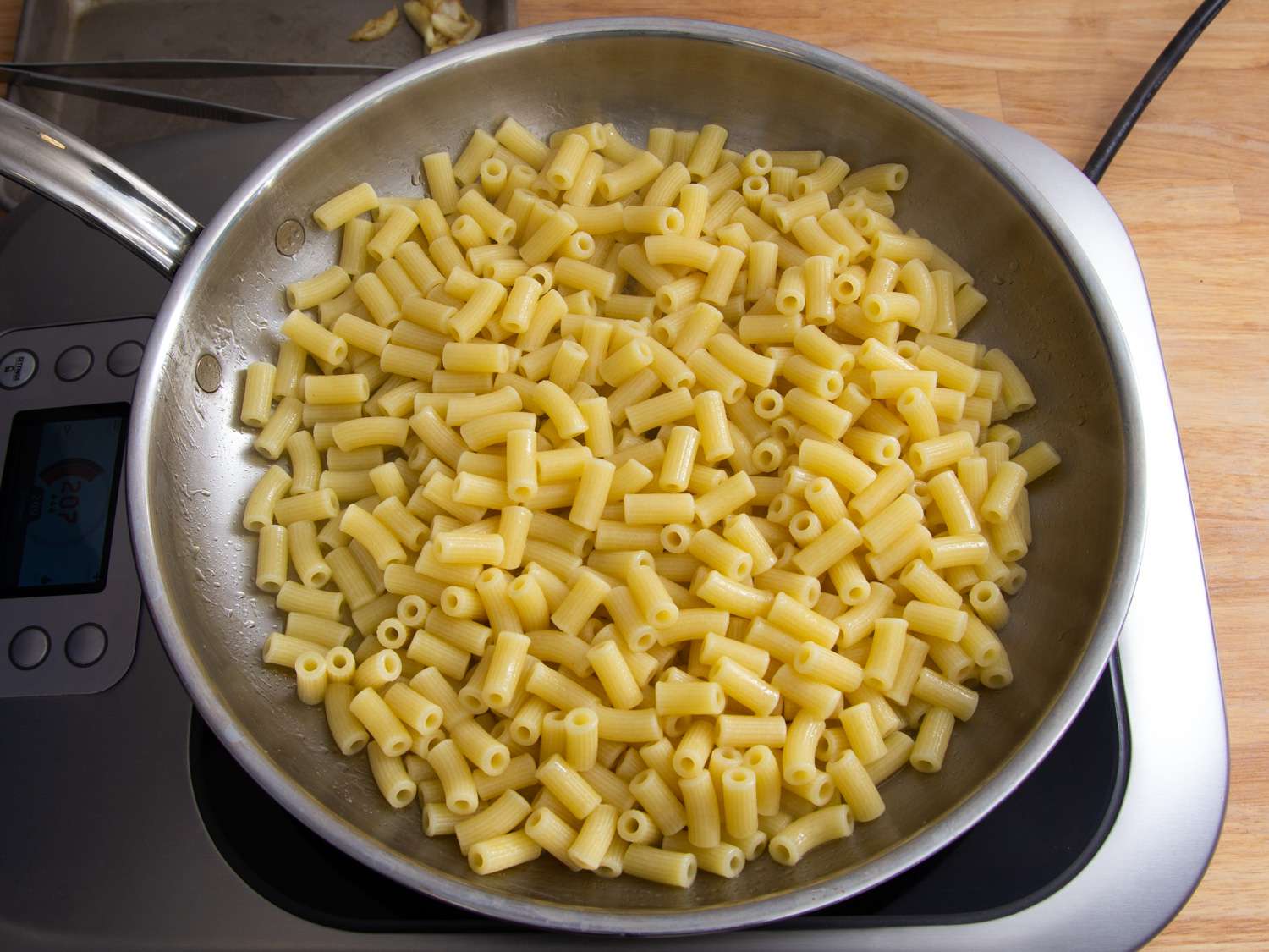 Short tubular pasta warming in a skillet.