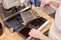 A person disassembles the Breville BES920XL Dual Boiler Espresso Machine