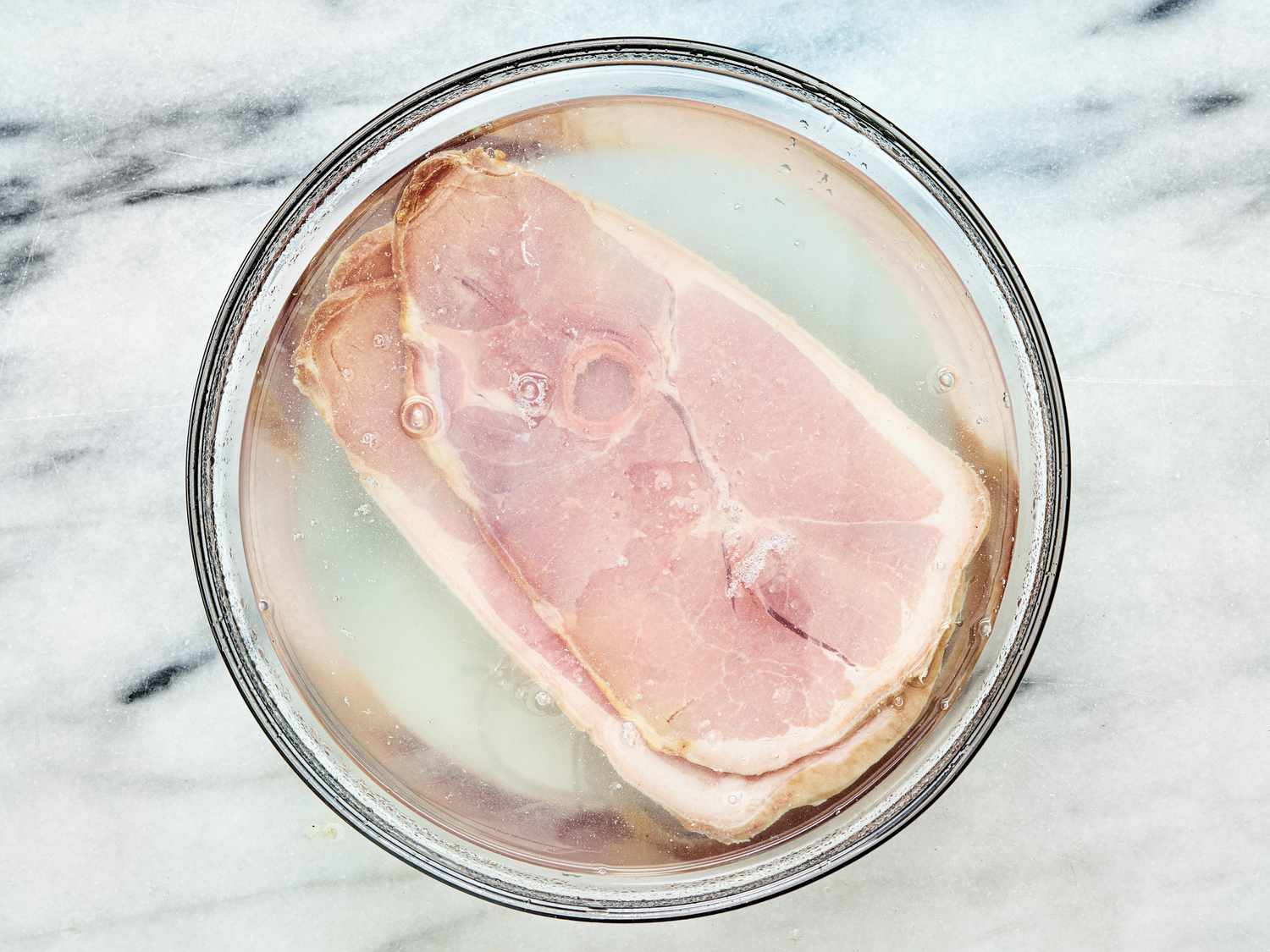 Overhead view of ham slices in water
