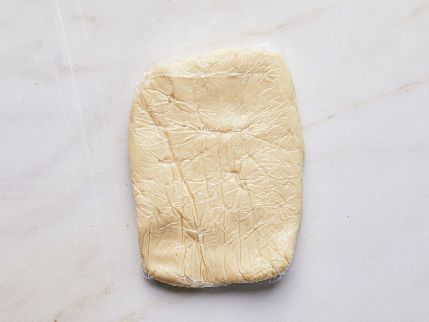 Log of concha's dough wrapped in plastic wrap 