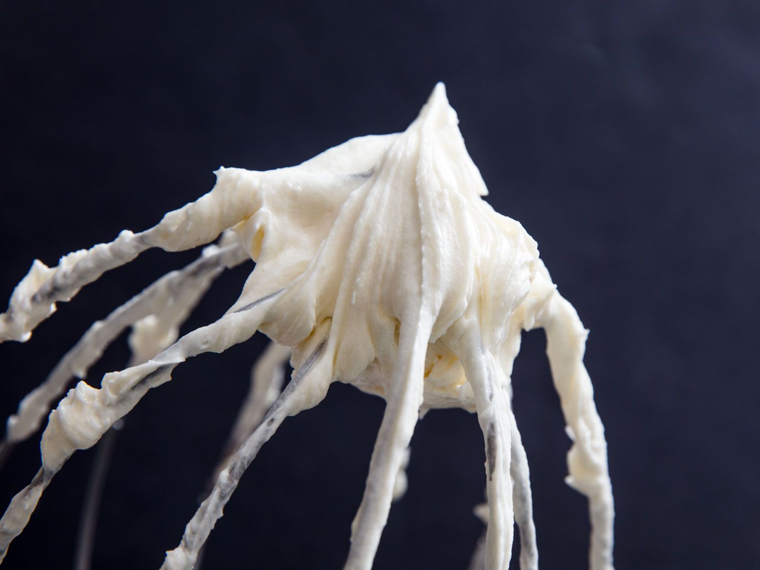 Flour frosting retaining its peak on a whisk attachment. 