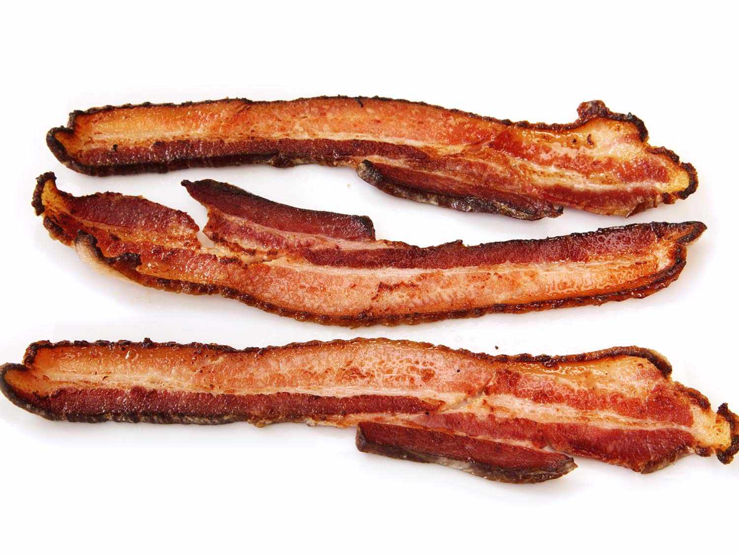 Several slices of finished sous vide bacon, crisp and browned around the edges.