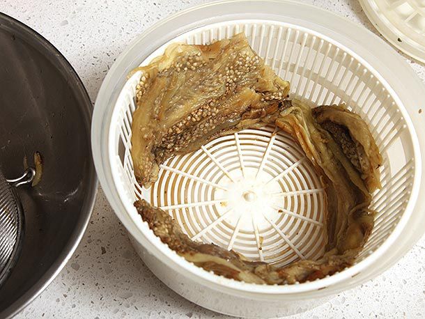 Cooked eggplant flesh in the bowl of a salad spinner