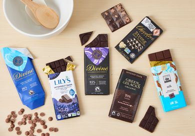 Numerous chocolate bars on a wooden countertop.