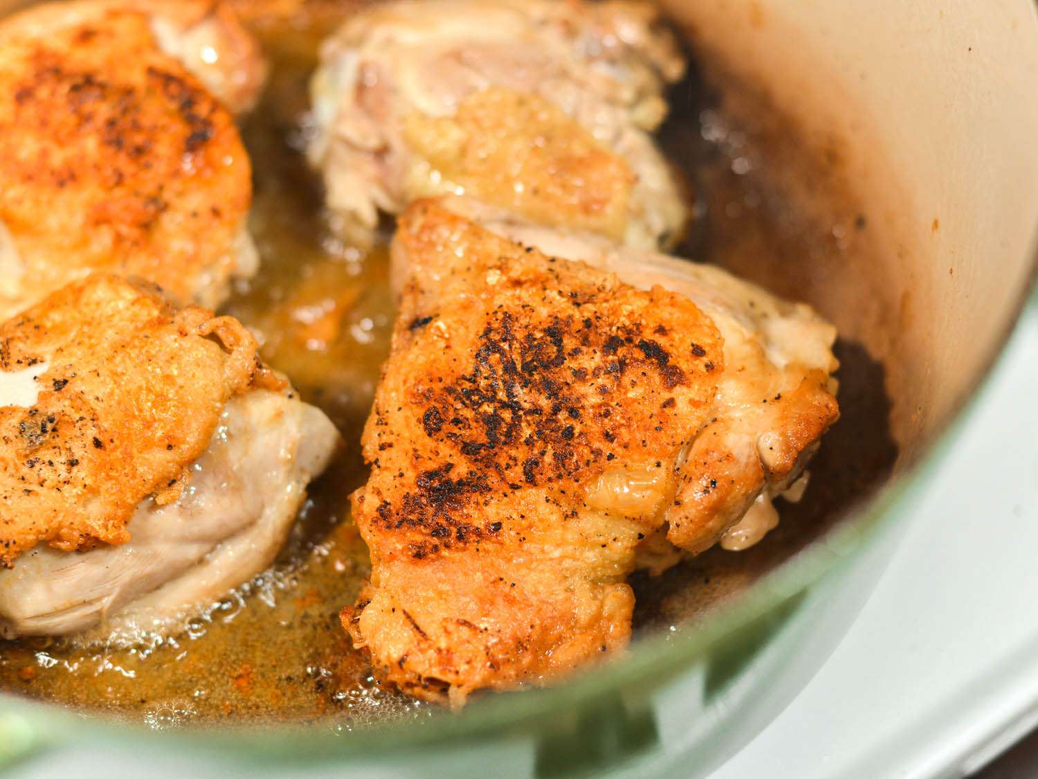 Close-up of chicken thighs browning in Dutch oven