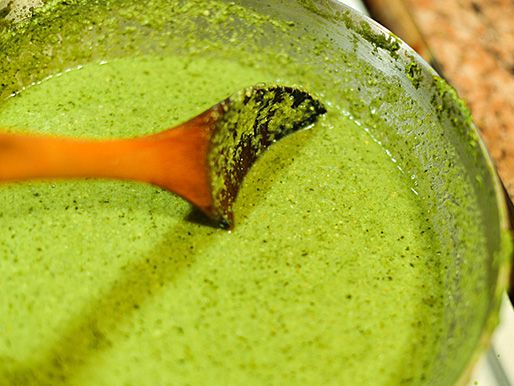 Stock is added to the green mole paste and simmered.