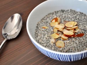Closeup of coconut almond chia seed pudding, served in a small bowl with a garnish of slivered almonds.