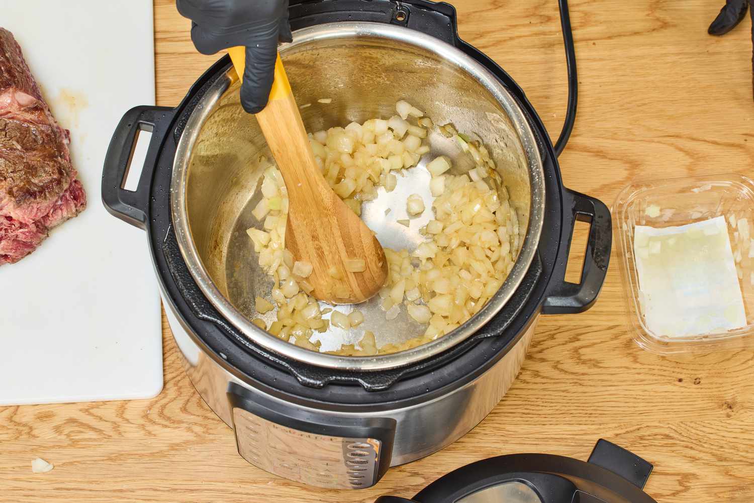 A person cooks onions in the Instant Pot Duo Plus 6-Quart 9-in-1 Pressure Cooker