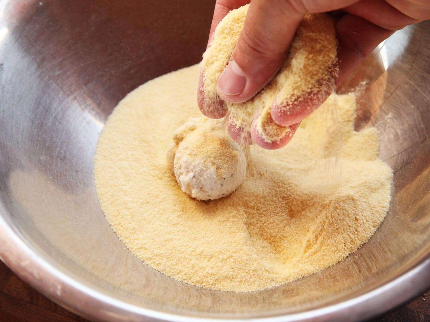 Coating ricotta balls with semolina. 