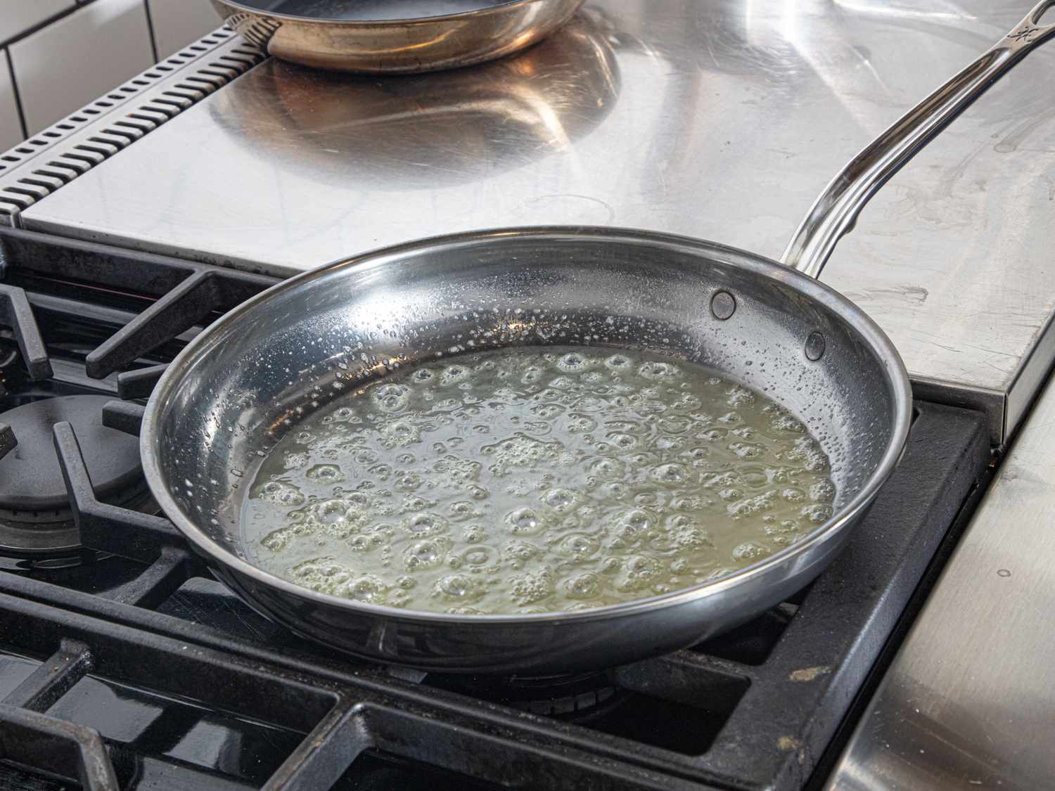A heated frying pan with melted butter on a stovetop