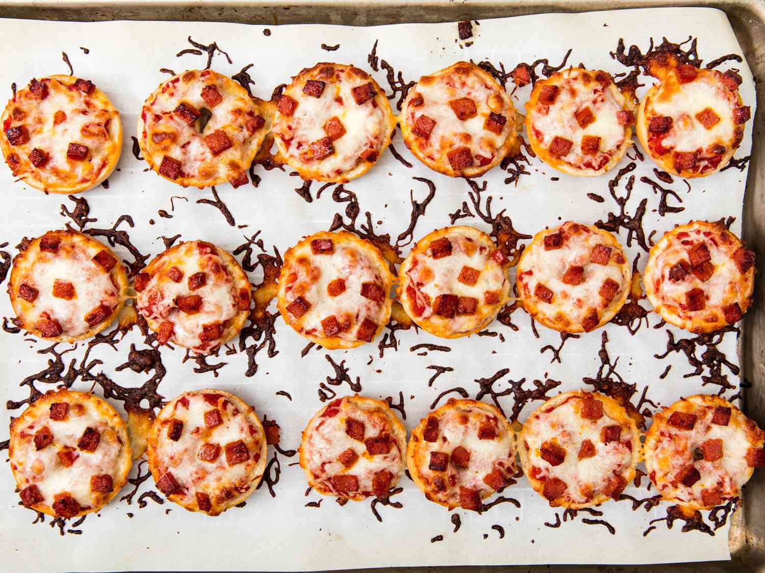 Overhead view of a baking sheet full of finished bagel bites, fresh from the oven.