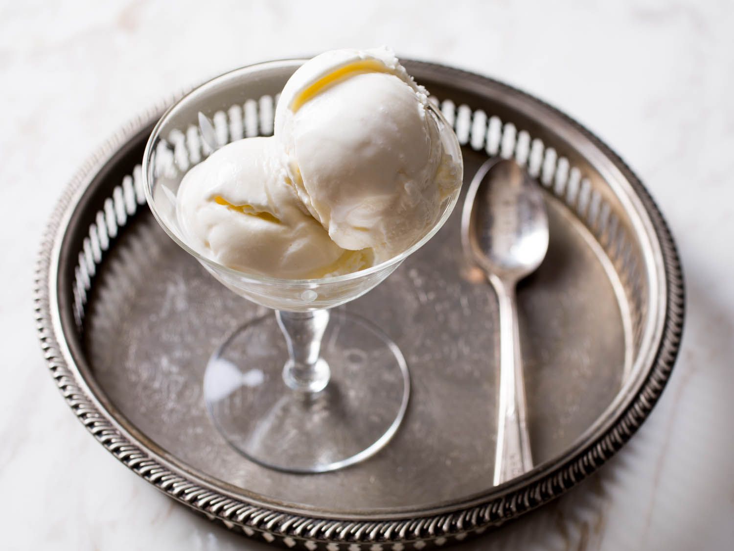 Two scoops of Philadelphia-style ice cream served in a stemmed ice cream bowl.