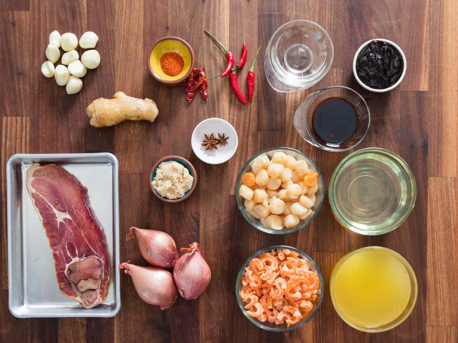 Ingredients for XO sauce in prep bowls on a wooden surface.