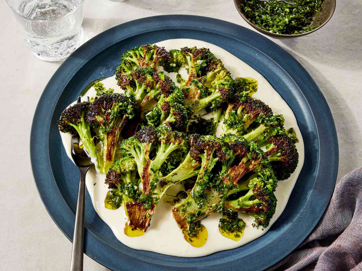 Overhead view of charred broccoli with taleggio cheese sauce