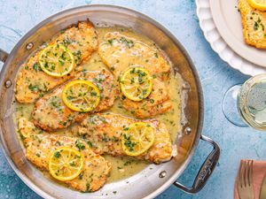 Chicken Francese served in a pan with lemon slices and sauce