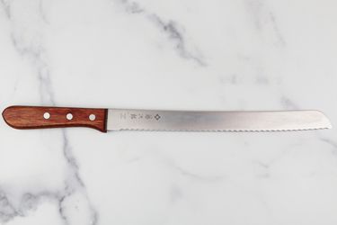 tojiro bread knife on marble counter
