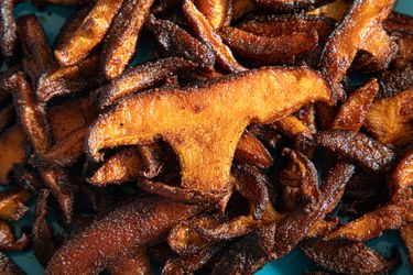 Roasted shiitake mushrooms on a blue plate (close up)