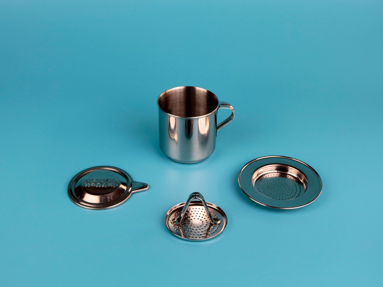 the four pieces of a phin filter on a blue surface