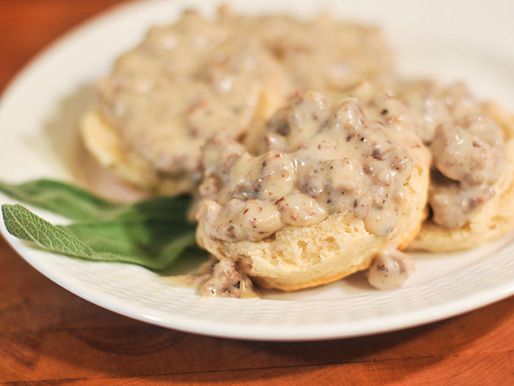 A plate of biscuits smothered with sausage gravy.
