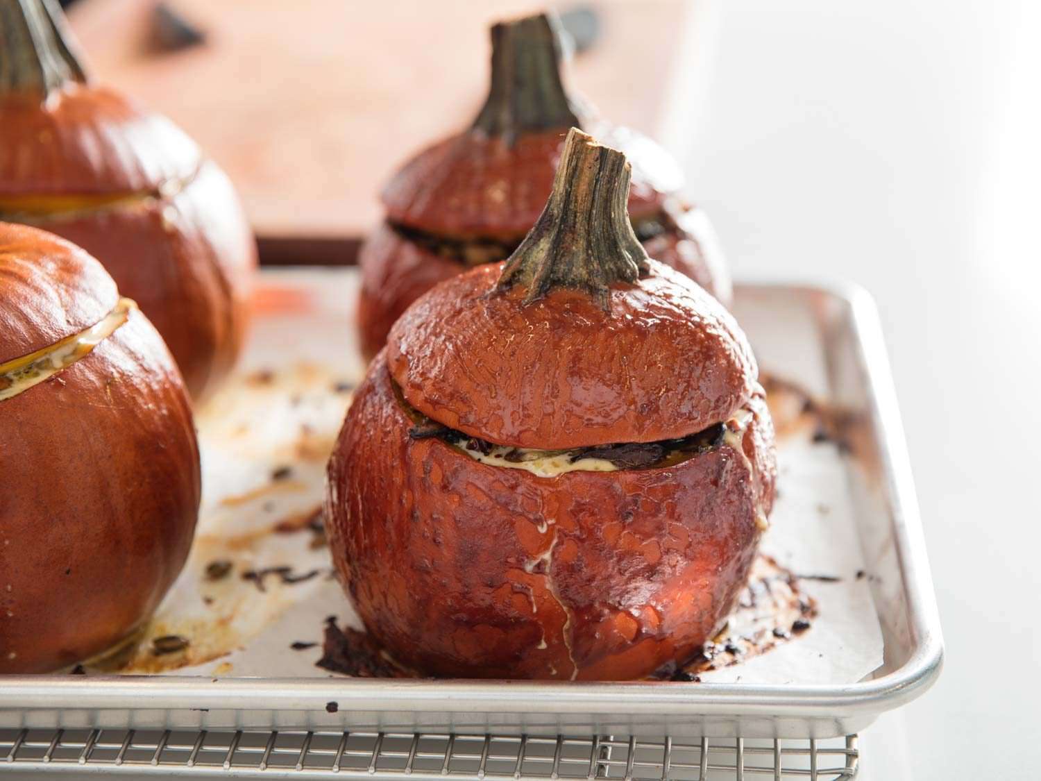 Stuffed pumpkins with Gruyere, mushrooms, kale (for Thanksgiving and holidays), on a baking sheet.