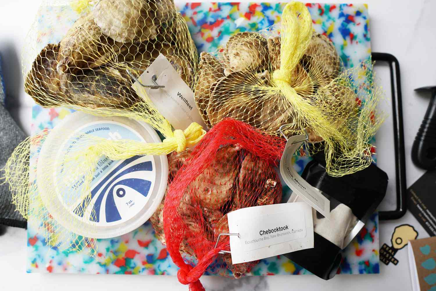 three bags of oysters on a colorful cutting board