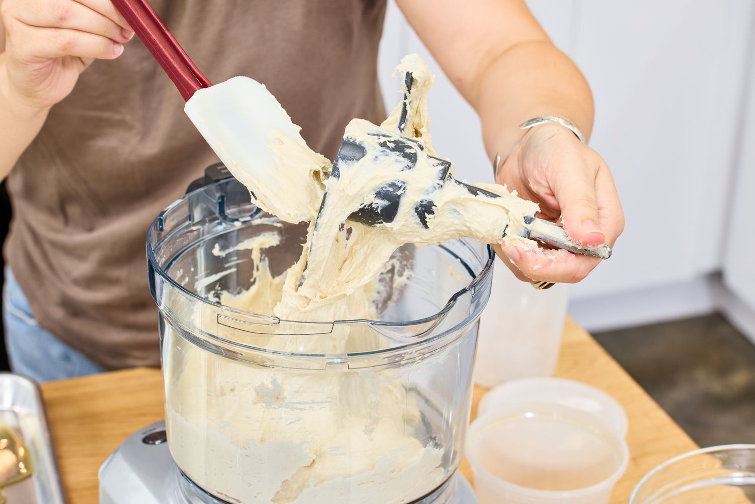 A person removes the blade from the Breville BFP660SIL Sous Chef 12-Cup Food Processor after making dough