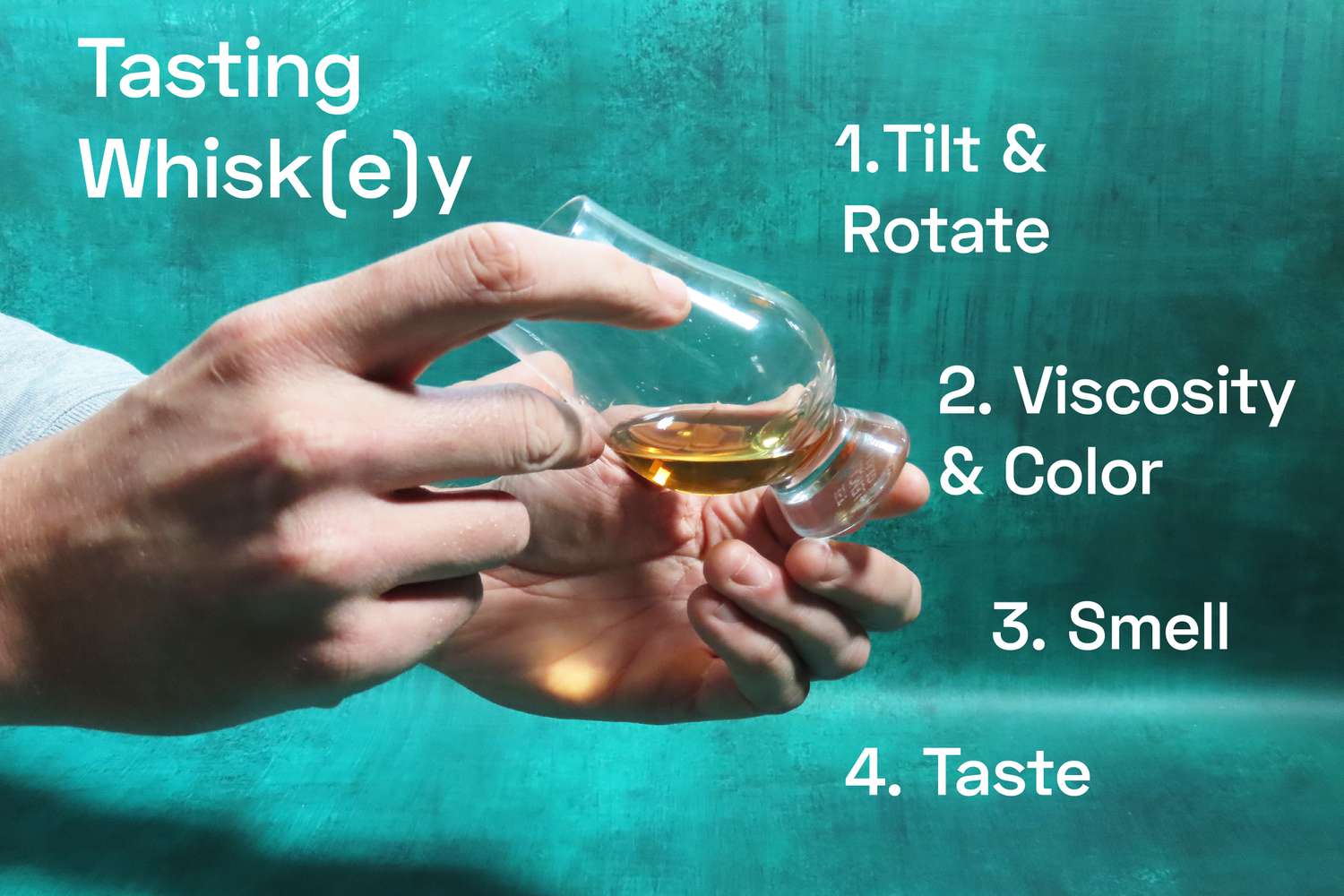 a hand holding and rotating a whisky glass