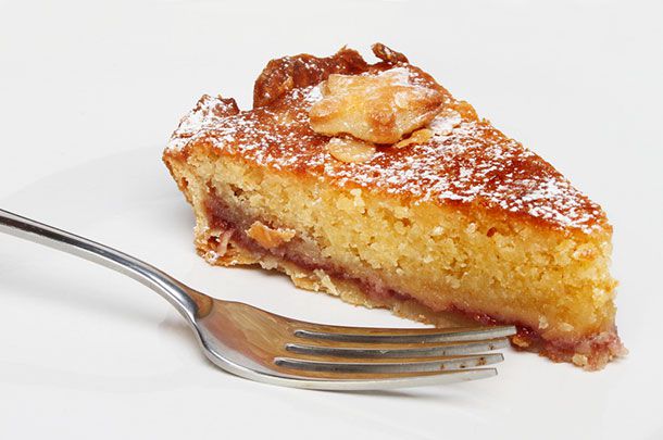 A slice of bakewell tart on a plate with a fork. 