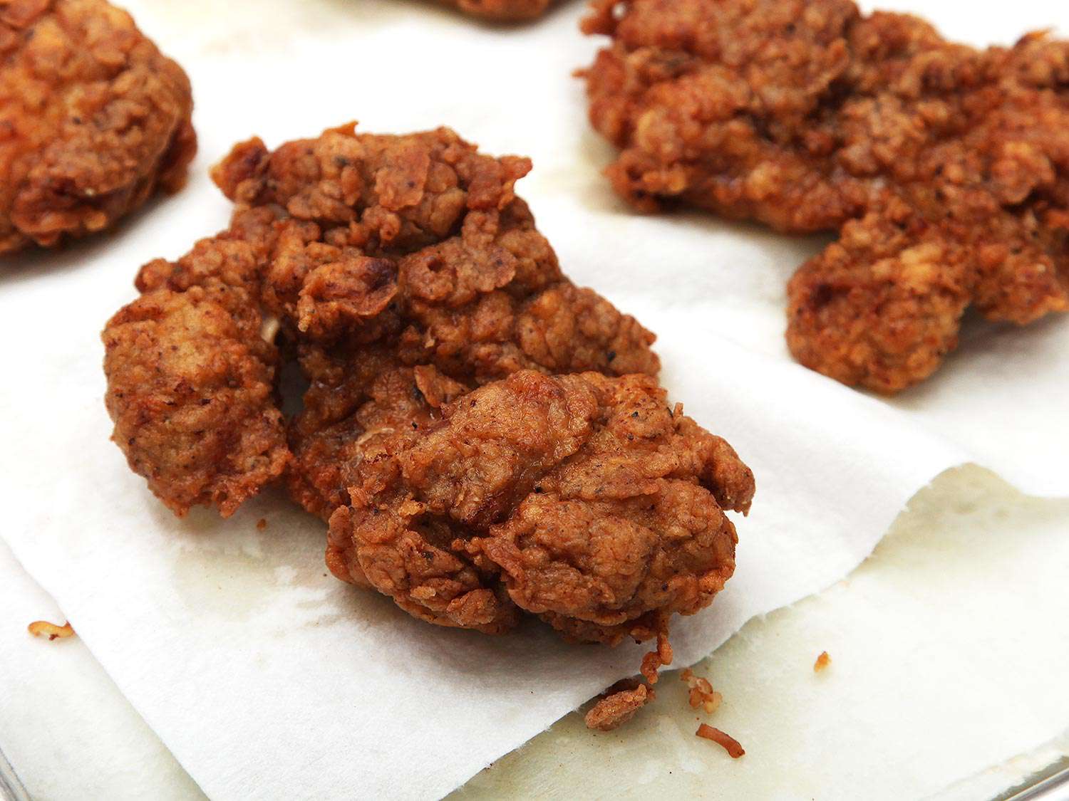 Pieces of fried chicken resting on a paper towel. 