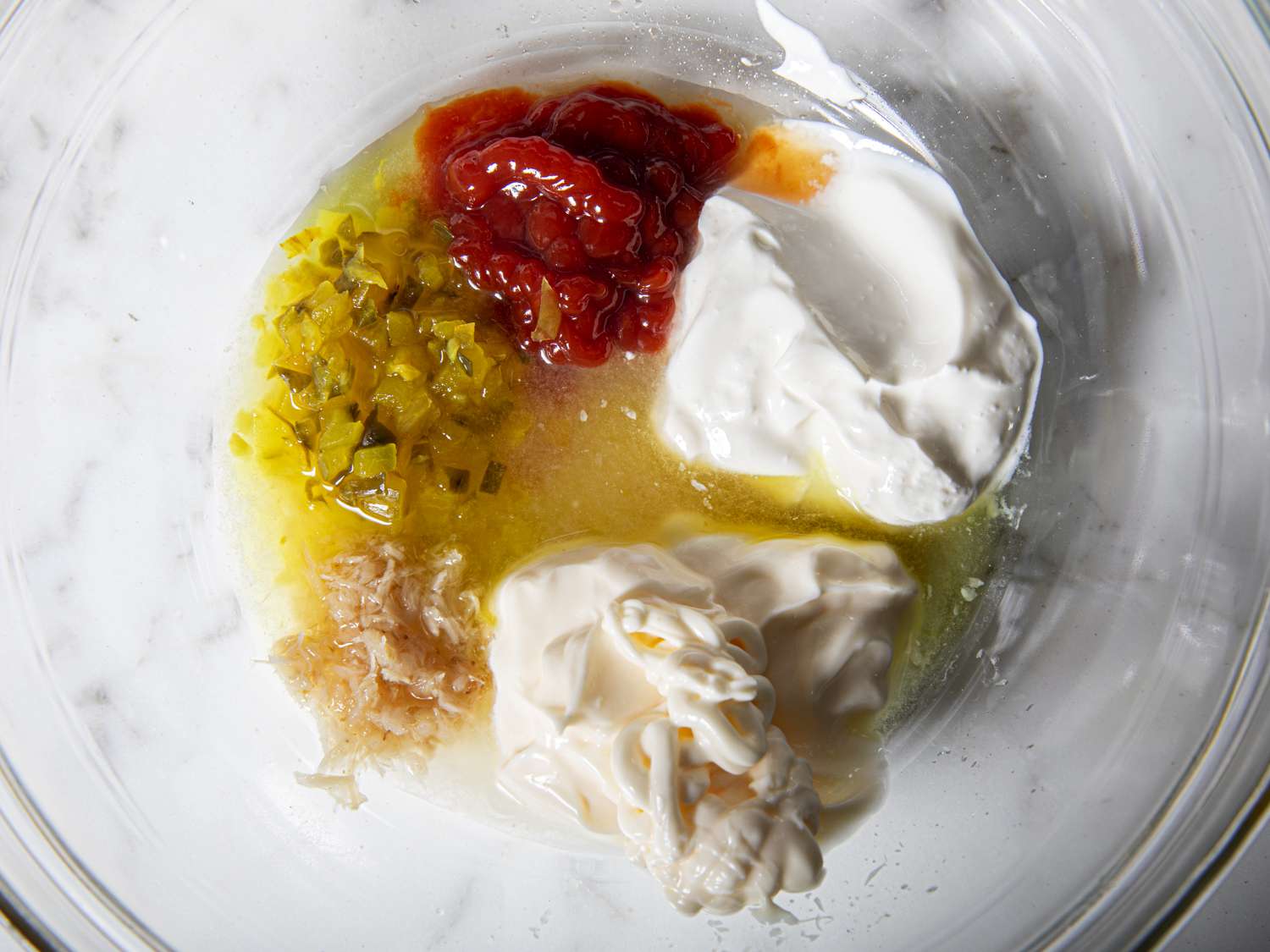 Overhead view of ingredients for russian dressing in a glass bowl