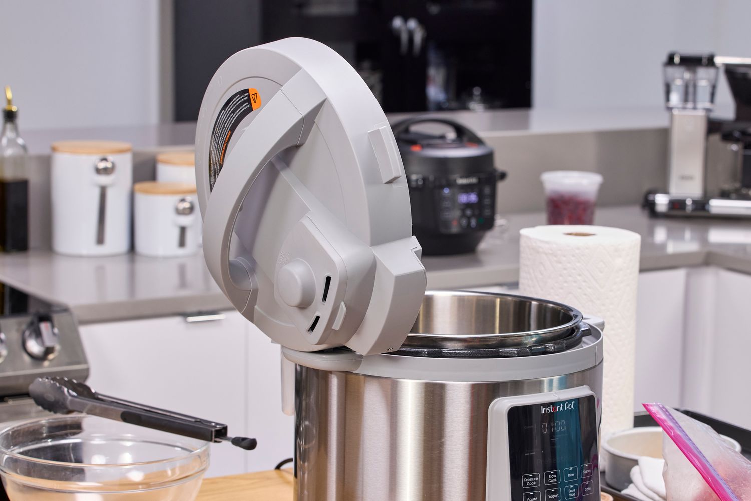 The Instant Pot Duo Plus 8 Quart Multi-Use Pressure Cooker with the lid off and resting on the handle