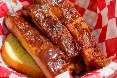 Closeup of Pineapple-Braised Ribs with Honey-Garlic Tomato Glaze, served in a basket on top of a thick slice of toast.