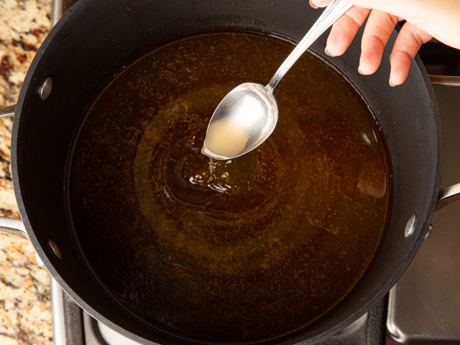 Overhead view of adding shrimp paste mixture to broth