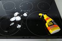 Electric stovetop with soapy residue and a bottle of Goo Gone kitchen degreaser