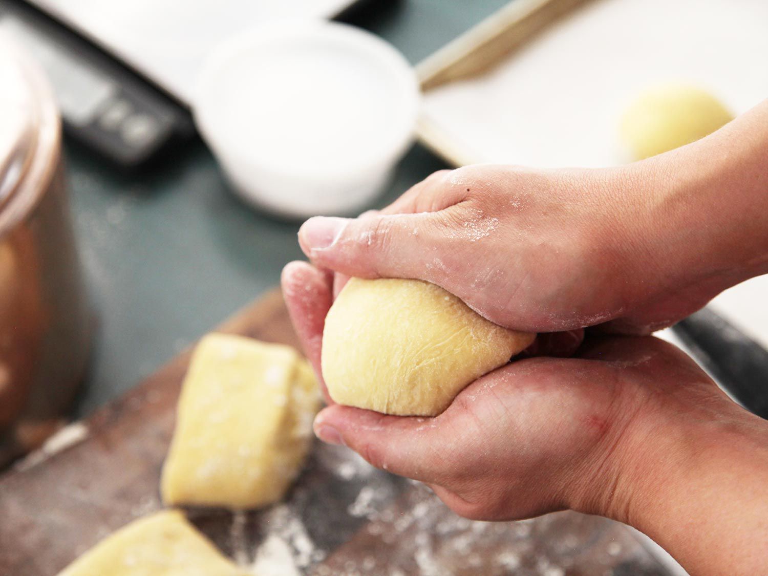 The author's hands finish forming the ball under the camera.