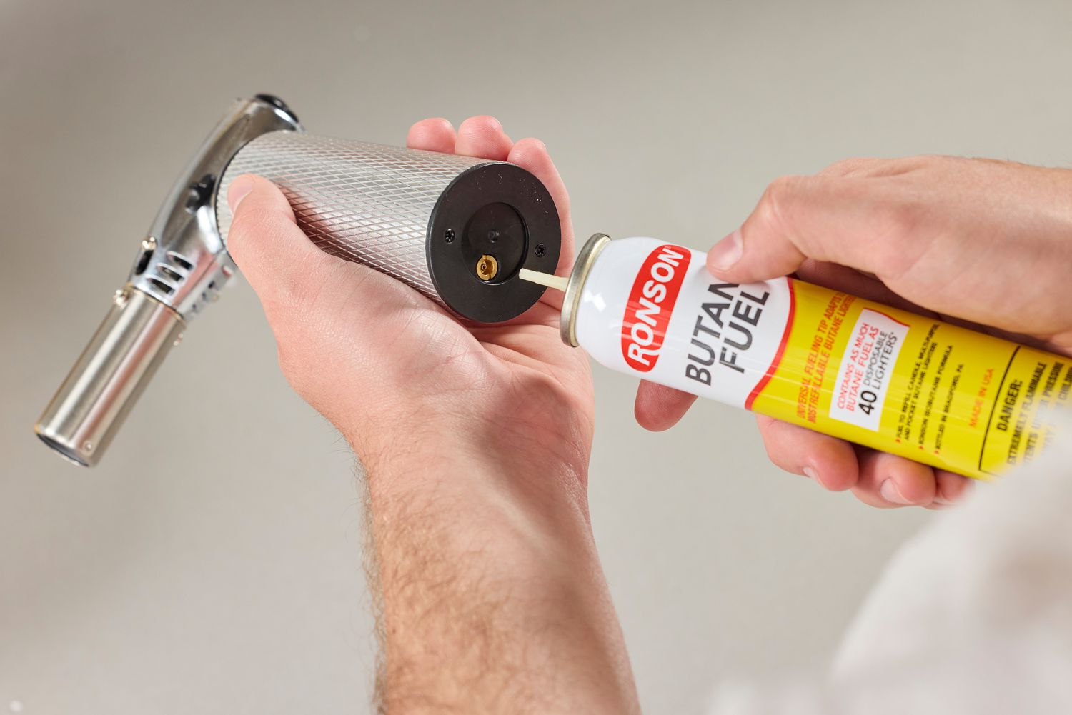 attaching a butane fuel canister to a torch