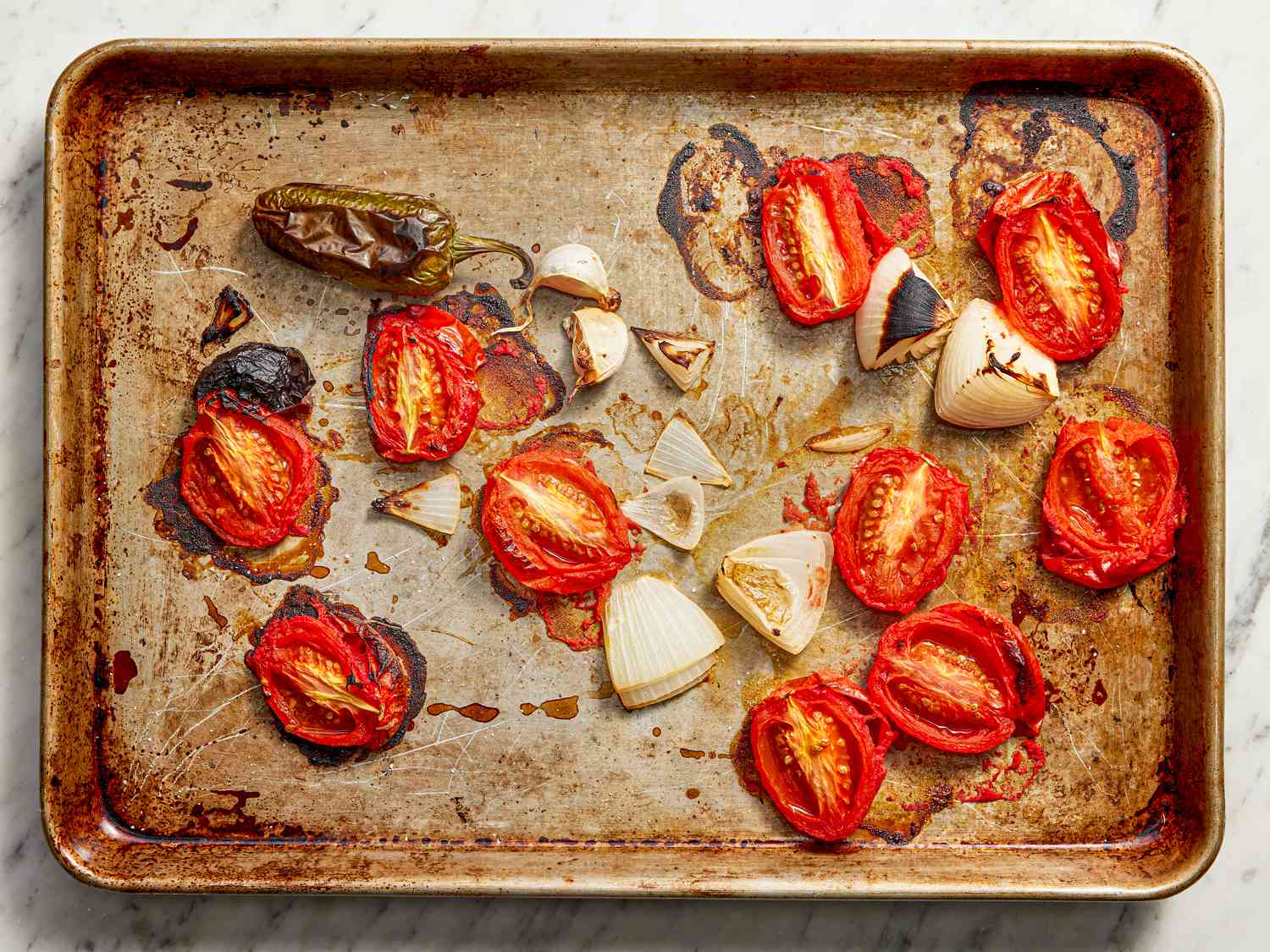 Roasted tomatos and onions on a baking sheet