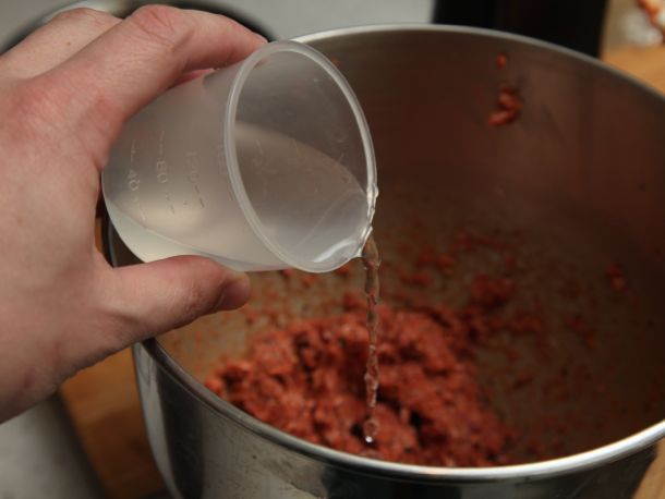 Ice water is added to the ground meat mixture.