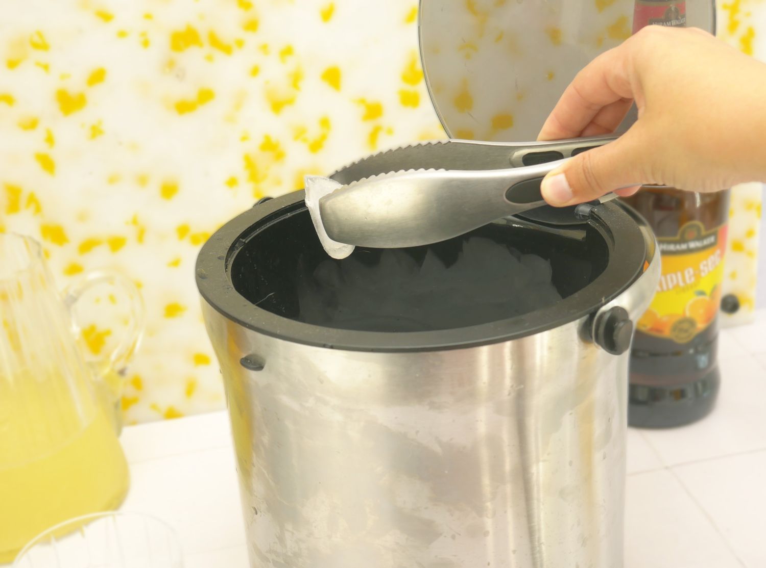 a person grabbing ice out of an ice bucket