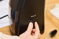 A person turns a dial on the Baratza ZCG495 Encore ESP Coffee Grinder