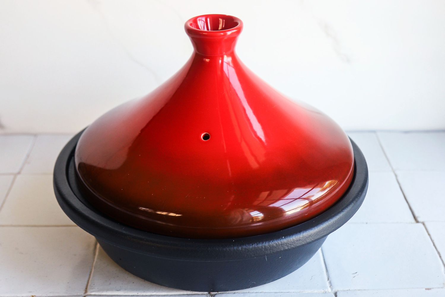 Kook red tagine on white tile surface